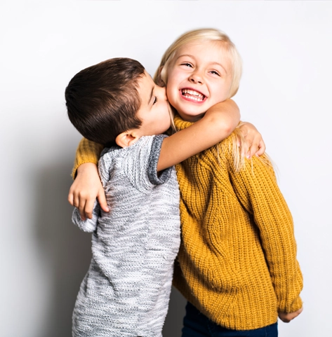 Two kids hugging.